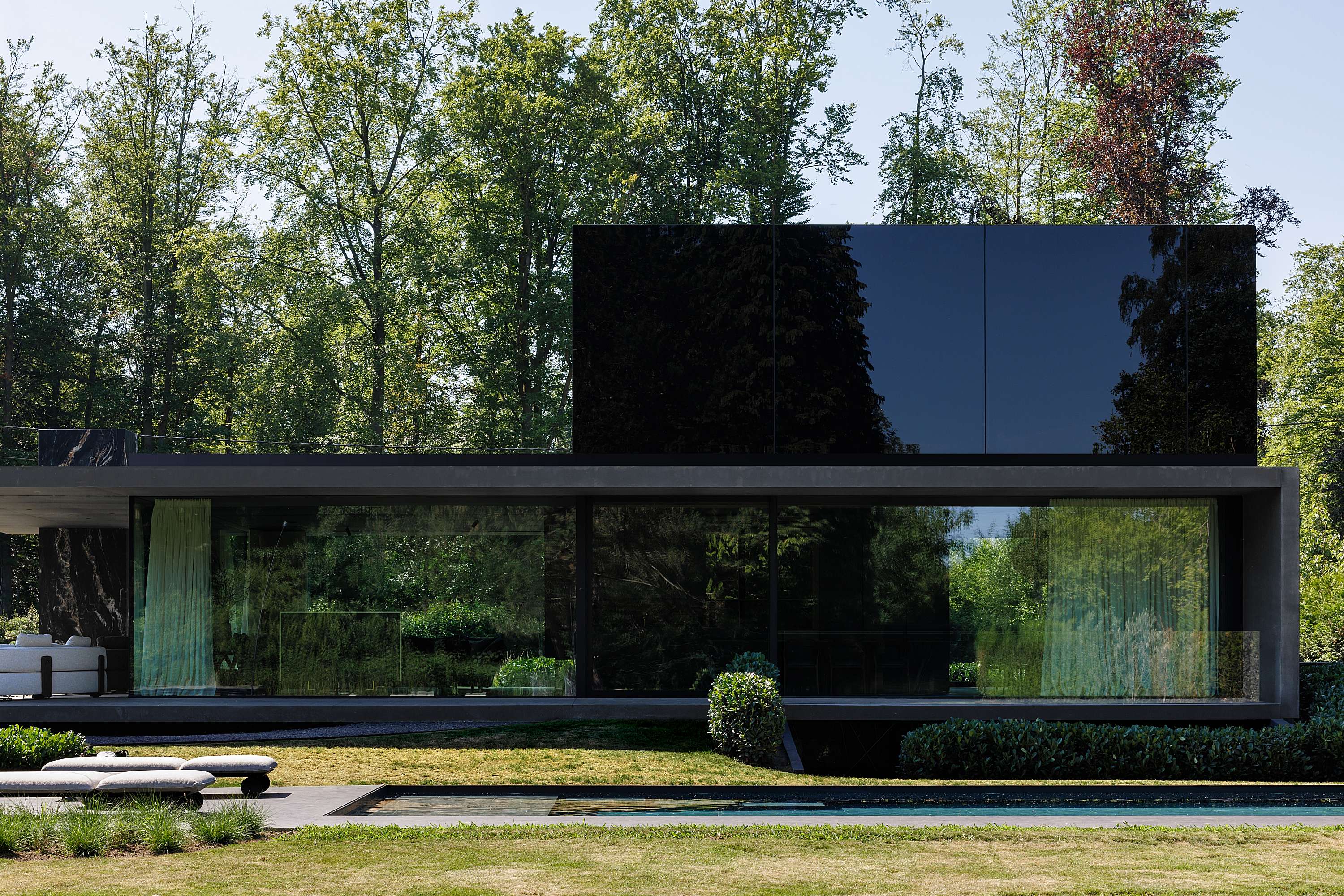 black concrete betonwoning duffel icoon.be architecten brasschaat_slanke luifel achterliggende dakopstand zwart glas leven in je tuin