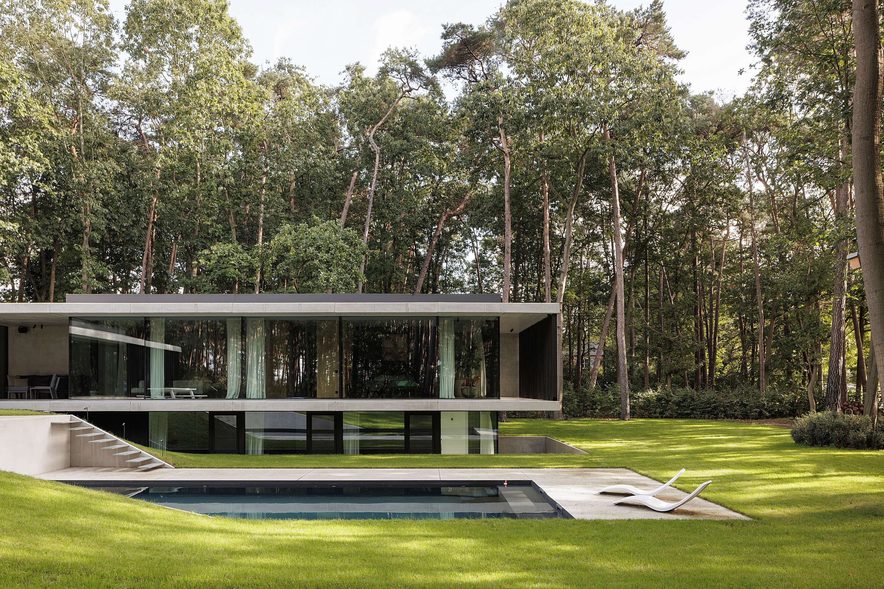 half ondergrondse hedendaagse betonwoning Zandhoven icoon.be architecten Brasschaat_kinderkamers half ondergronds slanke betonluifels dubbele dakrand zwembad niveauverschillen ken verelst