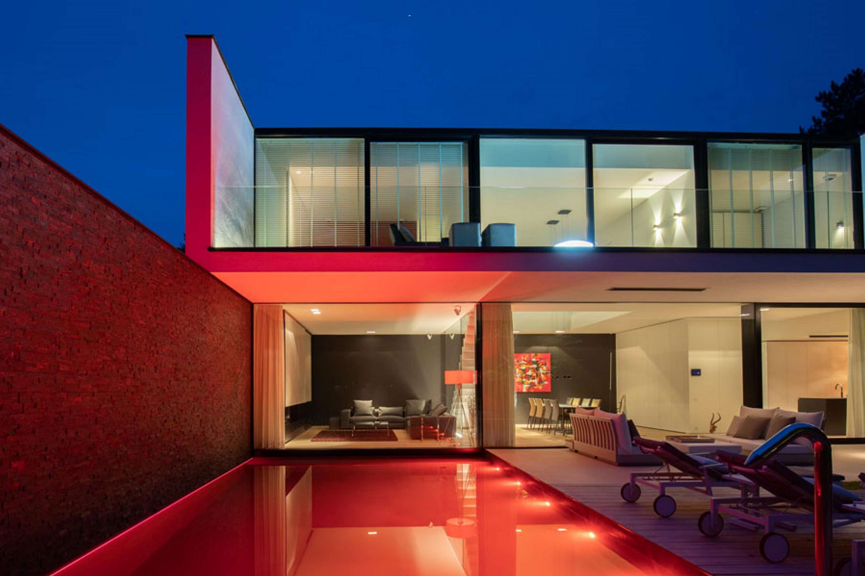 hedendaagse woning met zwembad en glazen garage in kalmthout_glazen achtergevel rgb gekleurd zwambadverlichting